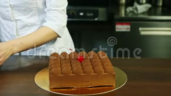 糖果师展示了带有巧克力和樱桃的奶油慕斯蛋糕视频的预览图