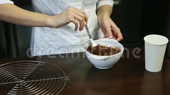 厨师统一配置的甜点在深白碗中配制液体巧克力釉视频的预览图