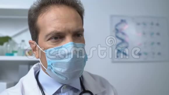戴口罩的专业医生用温度计测量女性病人的体温视频的预览图