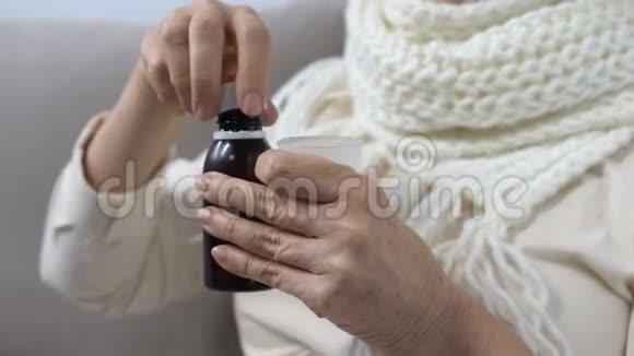 戴着围巾的老妇人拿着止咳糖浆对着镜头微笑有效的药物视频的预览图