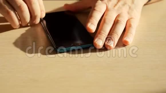 男人手从智能手机屏幕上取出保护膜视频的预览图