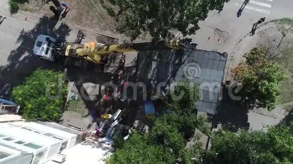 鸟瞰城市用挖掘机拆除房屋挖掘机装载卡车视频的预览图