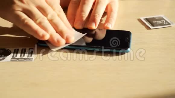 男性手清洁智能手机屏幕然后贴上保护膜视频的预览图