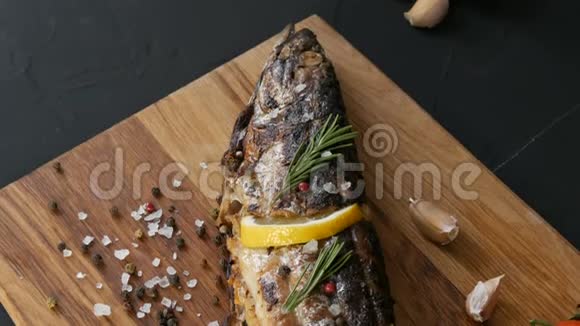 美味的新鲜鱼烟熏鲭鱼放在樱桃番茄旁边的木砧板上大蒜粗盐和视频的预览图