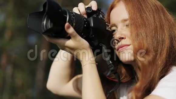 带照相机的红发女孩满脸雀斑正微笑着看着夕阳视频的预览图