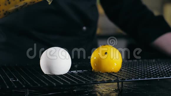 在缓慢的运动中在球甜点上涂上一层黄色的玻璃视频的预览图