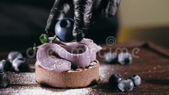 糕点厨师是把浆果放在蛋糕上并添加装饰元素特写视频的预览图