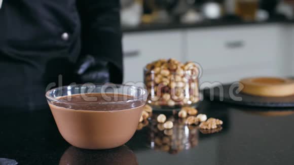 做蛋糕的厨师用一块巧克力蘸一块糖和坚果视频的预览图
