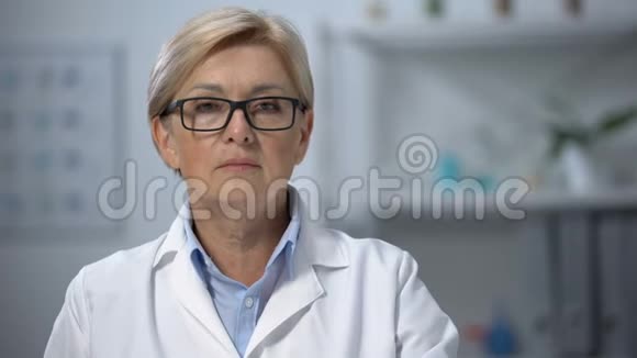 专业成熟的女医生在摄像机上显示电子体温计视频的预览图