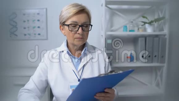 老年女医生向病人提供病史表格医院服务视频的预览图