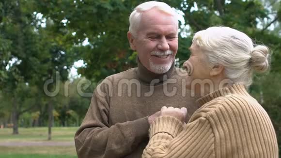 在秋天公园享受拥抱生活的成年夫妇爱和奉献慢节奏视频的预览图