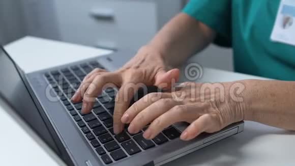 戴耳机的老年女医务工作者在笔记本电脑上打字在线咨询视频的预览图