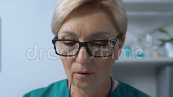 成熟的女性治疗师在文件中搜索病人的医疗表格医院视频的预览图
