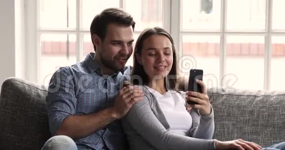 快乐的年轻人在家里使用智能手机社交媒体应用程序视频的预览图