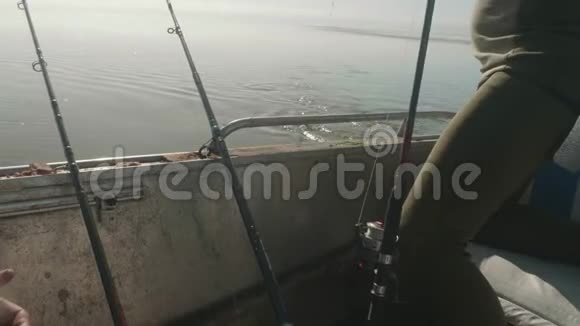 钓竿在船上渔夫把钓线上的大萨赞拉到钓鱼船上视频的预览图