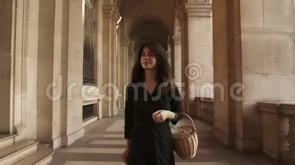 穿着黑色衣服的女人在卢浮宫博物馆外拍照视频的预览图
