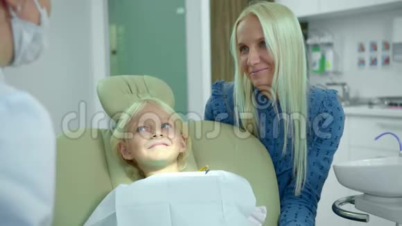 妈妈和女儿坐在一起和牙医说话视频的预览图