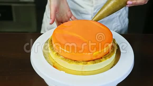 在白台上用橘色镜面釉装饰芝士蛋糕的工艺视频的预览图