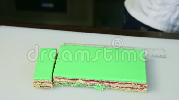 切配对刀切割绿色釉面奶油水果分层蛋糕视频的预览图
