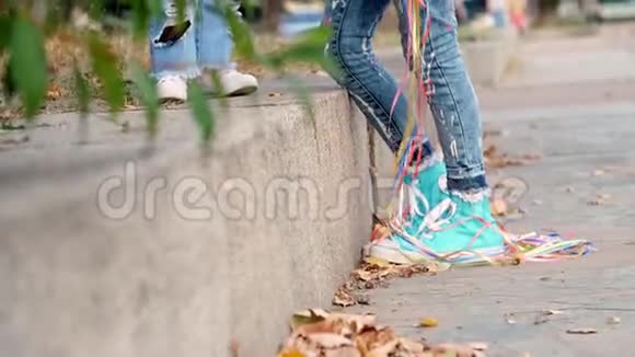 两个穿着牛仔裤西装的小女孩姐妹一个十几岁的女孩和一个小女孩正在公园里散步他们轻轻地拥抱视频的预览图