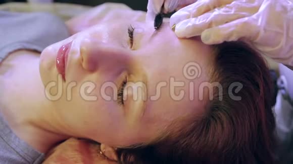 美容师用特殊的刷子把顾客的眉毛梳起来视频的预览图