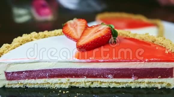 在半个芝士蛋糕上慢镜头中间有红色果冻和五颜六色的糖霜视频的预览图