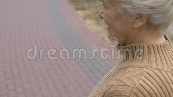 微笑的退休妇女看着孙女照片手握形象家人视频的预览图