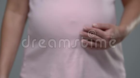 孕妇拿着肚子在镜头前展示药丸维生素用于健康支持视频的预览图