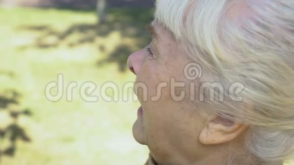 沮丧的退休妇女在户外擦干眼泪失去绝望感到孤独视频的预览图