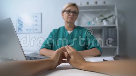 老年医生在检查时倾听紧张的女性触摸双手安慰视频的预览图