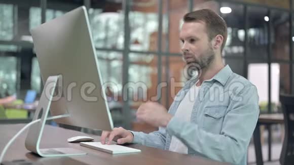 年轻设计师在电脑工作时思考问题视频的预览图