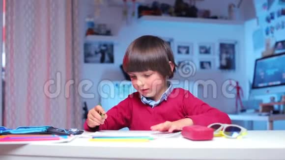 男孩坐在桌子旁站起来用铅笔指着铅笔盒视频的预览图