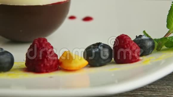 白色盘子上的蓝莓覆盆子橘子和薄荷视频的预览图