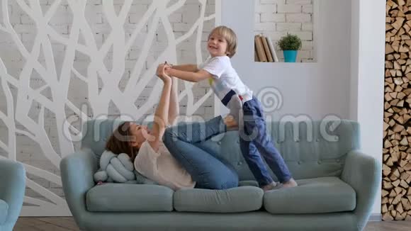 快乐的妈妈正在和她的儿子玩把他像飞机一样举起来孩子和妈妈一起玩印度支视频的预览图
