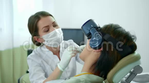 牙医工作她的病人戴着虚拟现实眼镜视频的预览图