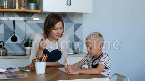妈妈帮儿子在厨房做家庭作业有家庭生活方式和教育观念的人视频的预览图
