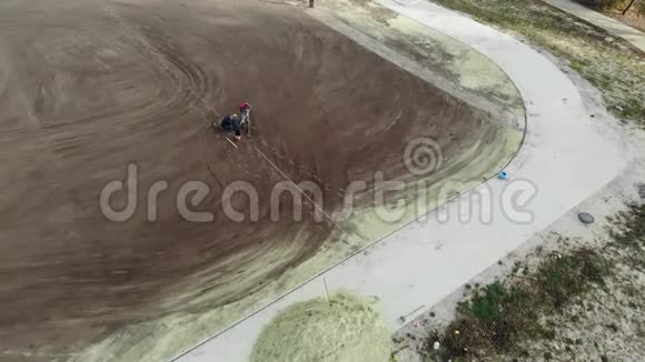 在学校足球场上组装灌溉系统的工人的空中射击视频的预览图