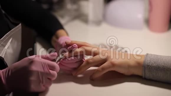 专业的美甲师用剪刀剪除指甲附近干燥的角质层皮肤专业人士特写短片视频的预览图