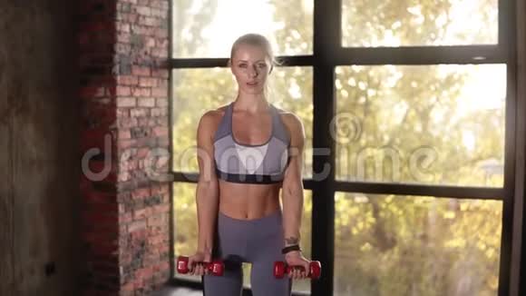 女子运动员或教练训练与小红哑铃在空健身俱乐部年轻女性训练手部的重量视频的预览图