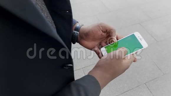 在街上打电话的商人高管手里拿着智能手机视频的预览图