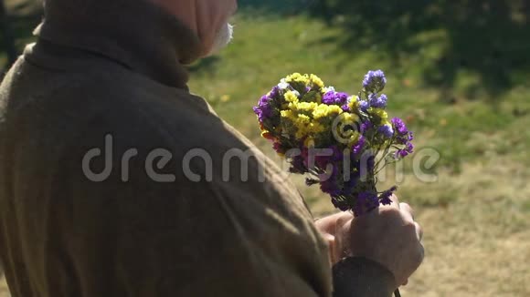 老人在手中嗅着野花在户外享受大自然约会礼物视频的预览图