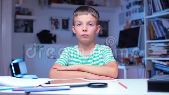 男孩坐在学校的桌子旁示范如何举手视频的预览图