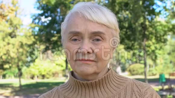 白种人退休女士坐在公园宁静的乡村老一代视频的预览图