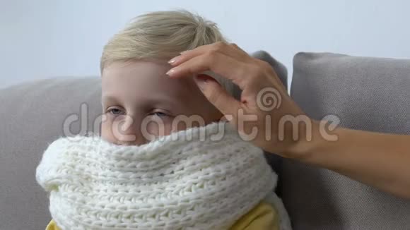 母亲用手抚摸生病的孩子的额头检查体温照顾父母视频的预览图