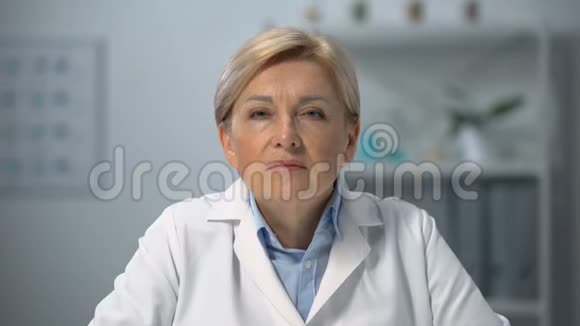 成熟的女医生眯着眼睛自我检查视力医疗保健视频的预览图