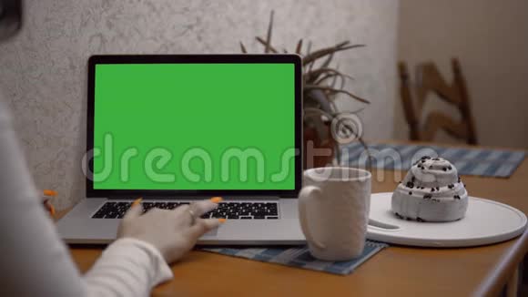 在笔记本电脑里工作的女人肩膀上放着绿色的屏幕在家里做模型视频的预览图