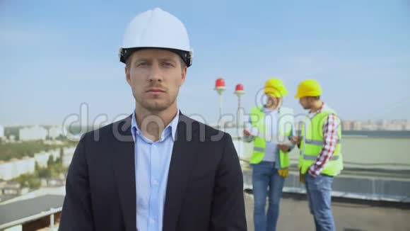 戴头盔的男建筑师戴着摄像机站在屋顶工人背景视频的预览图