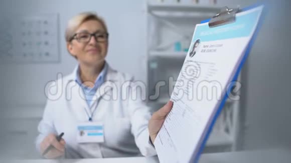 快乐的女治疗师带着医疗病人卡微笑保健视频的预览图