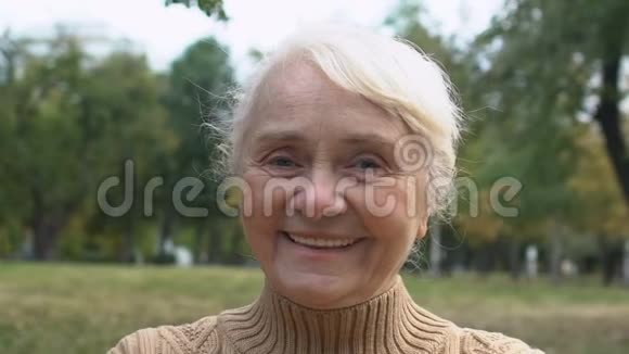 70岁的幸福女人用手显示心的标志爱的象征特写视频的预览图