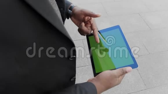 商人在街上滚动平板电脑企业家在户外工作视频的预览图